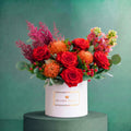 Scarlet Veil autumn hatbox of orange roses, nutan, red berries and eucalyptus, Bloom Magic